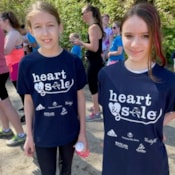Two girls in Heart & Sole shirts smiling.